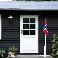 Hvitmalt flaggstang med norsk flagg, rød, hvit, blå